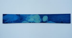 A long horizontal painting on silk depicting pale lotus-seed-like figures with eye-like centres emerging and partly disappearing within layered blue water and dark ripples.