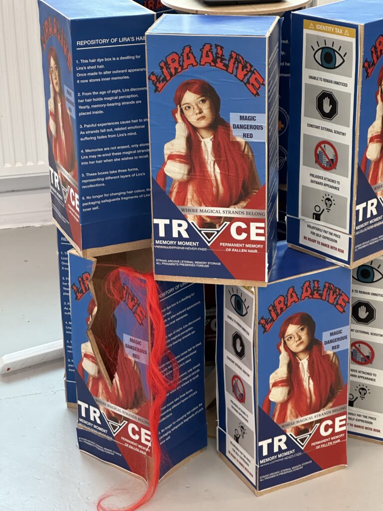 MDF hair‑dye boxes, one broken crate with hair spilling out within degree show installation.