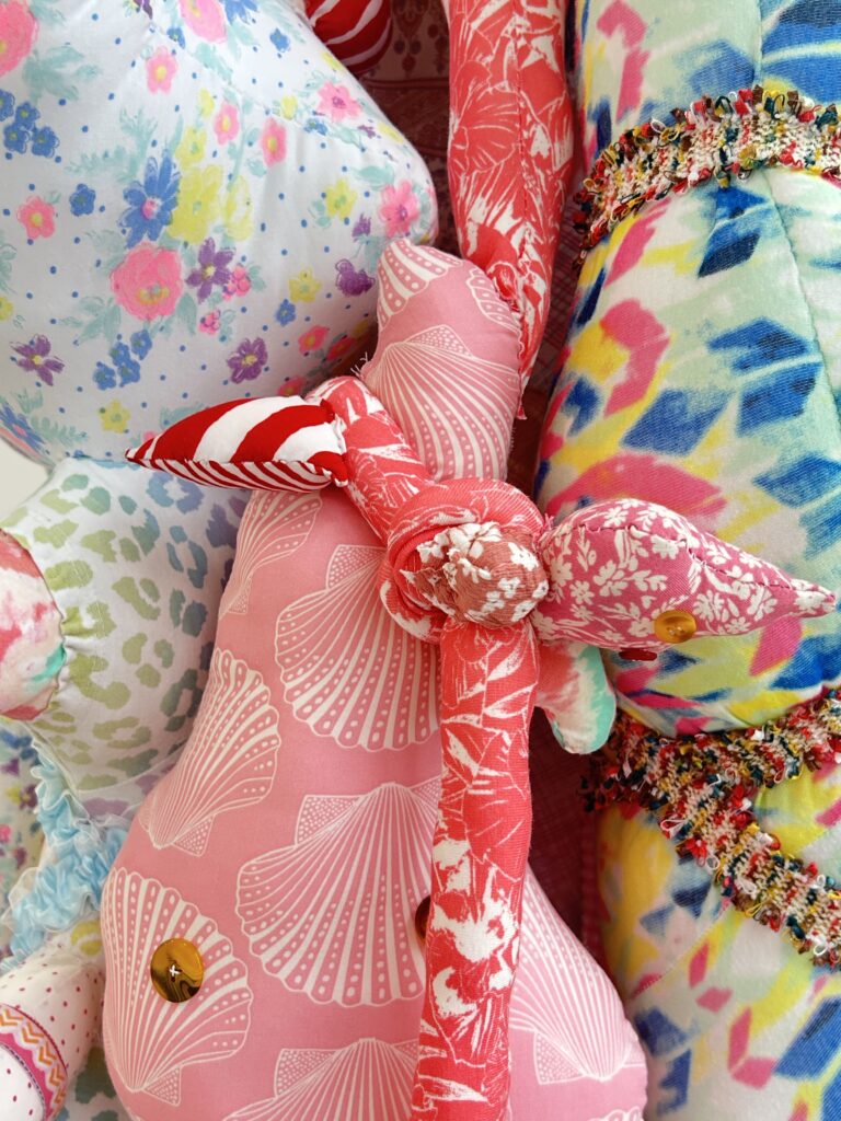 A close-up view showing the layered textile forms and hand-sewn details of ABEBE.