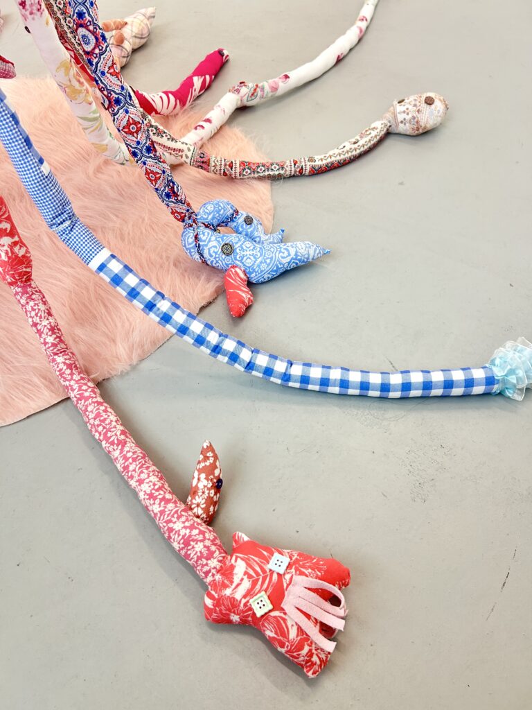 The lower section of the suspended textile sculpture extending onto the gallery floor.