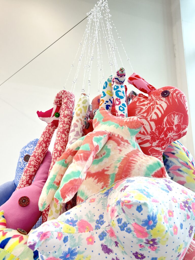 A close-up view showing the layered textile forms and hand-sewn details of ABEBE.