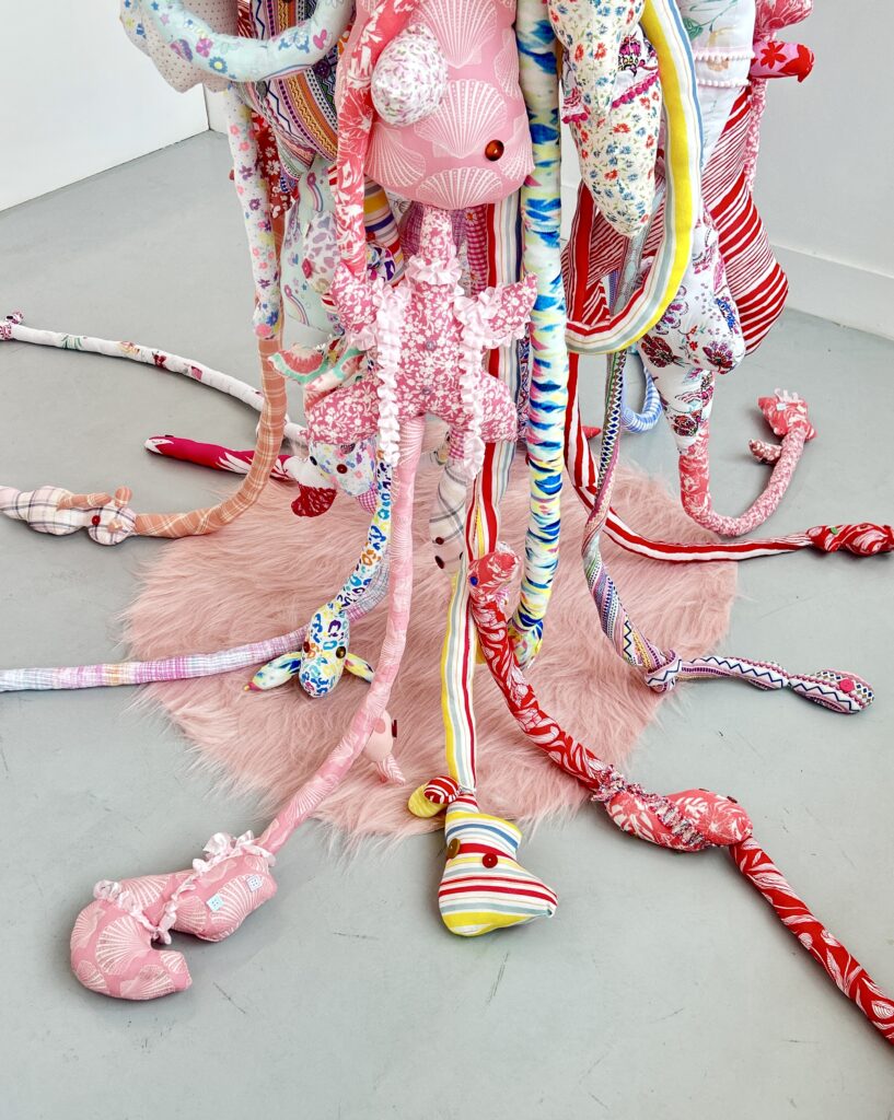 The lower section of the suspended textile sculpture extending onto the gallery floor.