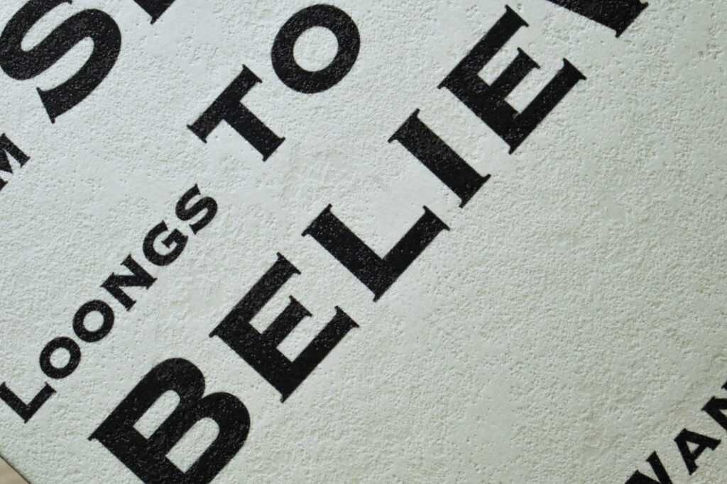 Close-up of the cover, showing the textured surface of the almond-coloured paper and the printed typography.