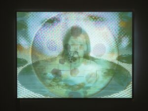 Soft Captivity, 2026. A layered image featuring a blurred female face and fragmented digital textures, presented on backlight film in an LED light box.