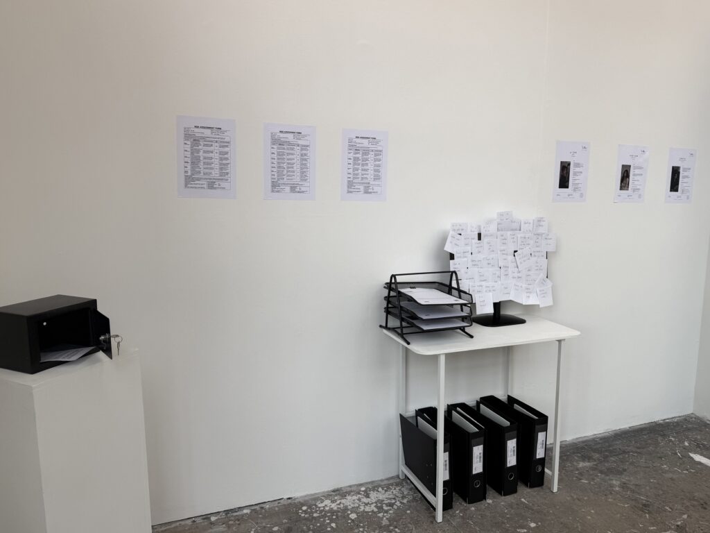 Installation view of the LMy Artist Agency office with artist documents, working notes, archive folders and an open safe.