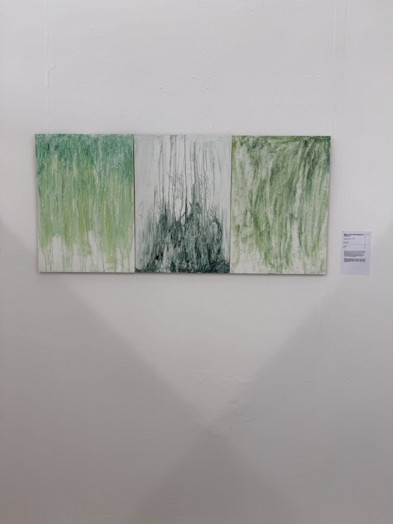 Three green and white abstract panels installed side by side on a white gallery wall.