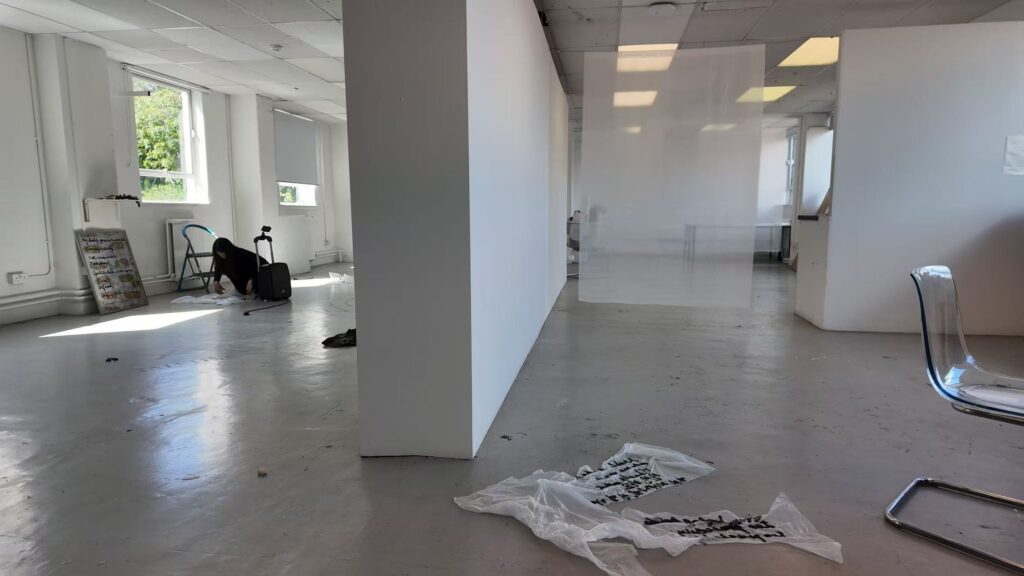 Installation process for The Uncanny: What Remains, showing materials arranged across the exhibition floor and the partially installed gallery space