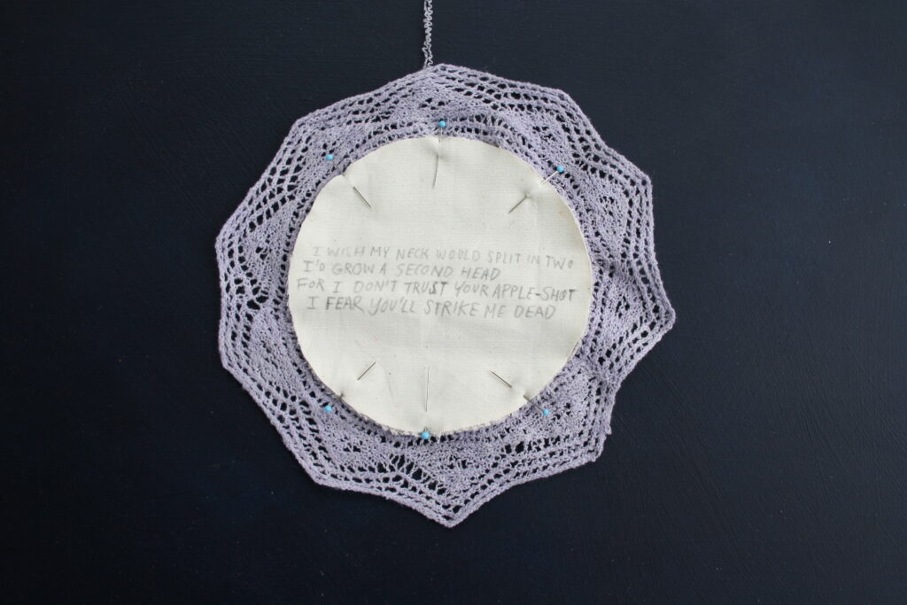 A hand-knitted lace doily on a dark blue background.
