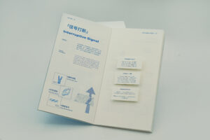 An open publication displaying the Interruptive Signal family across a double-page spread, with bilingual typography, blue graphic elements and three raised paper annotation blocks on the right-hand page.