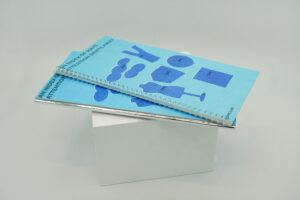 Two physical editions of An Index of Ways Attention Drifts Away are displayed together on a white block, showing the front covers of both publications.