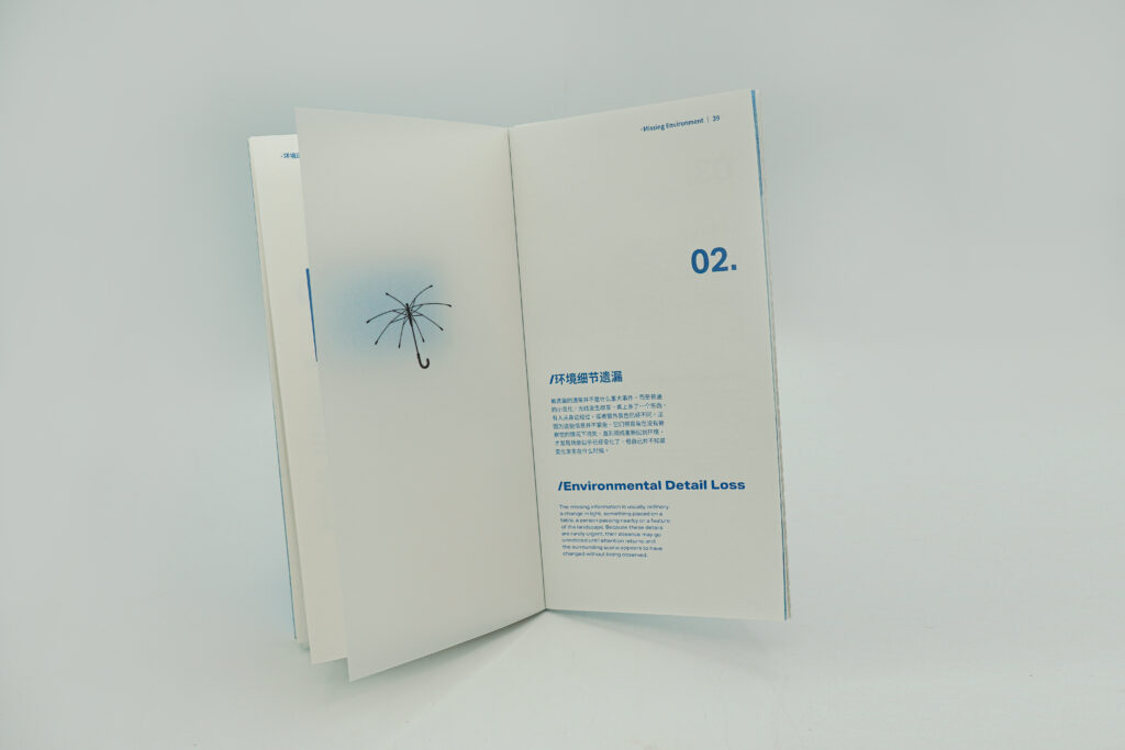 An open publication showing the Environmental Detail Loss entry. A small umbrella illustration appears on the left page, while the right page contains bilingual text and a large blue number 02.